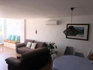 a living room with a couch and a table at Ático a 200m del mar. in Jávea