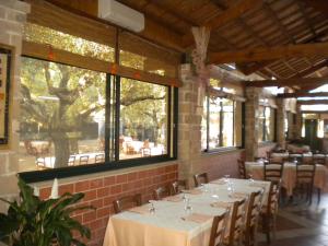 een eetkamer met witte tafels, stoelen en ramen bij Su Barroccu in Riola Sardo