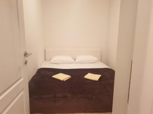 a small bedroom with a bed with two towels on it at Apartman Dunjica in Pale