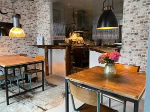 a kitchen with two tables and a vase with flowers on it at La Bouchère 33 in Meuzac