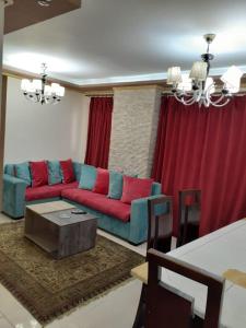 a living room with a red and blue couch at Borg Barka - Families Only in Alexandria