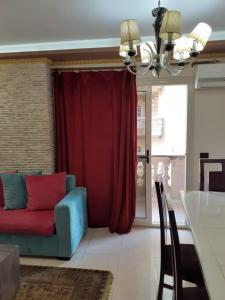 een woonkamer met een bank en een rood gordijn bij Borg Barka - Families Only in Alexandrië