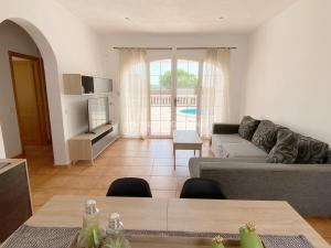 ein Wohnzimmer mit einem Sofa und einem Tisch in der Unterkunft Villa Vergara in Cala en Porter