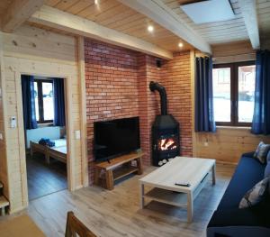 a living room with a brick wall and a fireplace at Słoneczne Chaty Kasina Wielka in Kasina Wielka