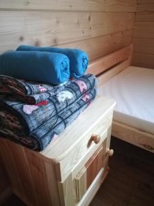 a bed and pillows sitting on top of a wooden cabin at Słoneczne Chaty Kasina Wielka in Kasina Wielka