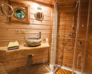 a wooden bathroom with a sink and a shower at Gaïa - Les Cabanes du Chêne Rouvre in Saint Die