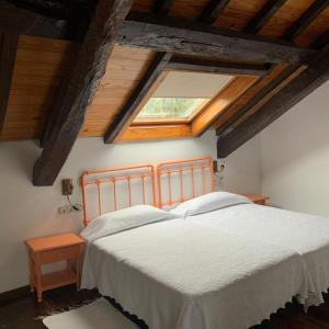 ein Schlafzimmer mit einem weißen Bett und einem Dachfenster in der Unterkunft Casa Goris in Merza
