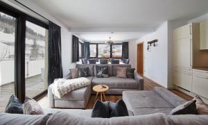 a living room with two couches and a table at SonnAlm Appartements in Saalbach Hinterglemm