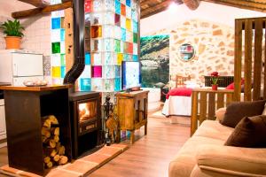 ein Wohnzimmer mit einem Kamin und einem Sofa in der Unterkunft Casa Rural El Cuco in Robledillo