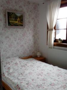 ein Schlafzimmer mit einem Bett und einem Bild an der Wand in der Unterkunft Roztoczański Dworek in Zamość