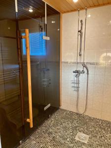 La salle de bains est pourvue d'une douche avec une porte en verre. dans l'établissement Levi Kaakkuri 6, à Levi
