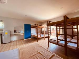 a room with three bunk beds and a refrigerator at Cerca Parola Beach Resort in Malabrigo