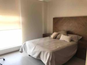 a bedroom with a bed with white sheets and a window at Luxury house with all the amenities Gym Seg Aa cal Pool Tv Wifi in Querétaro