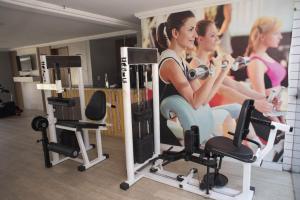 a room with two women exercising in a gym at Flat Natal - Localização TOP e WIFI in Natal