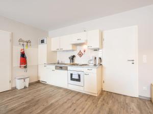 a kitchen with white cabinets and a wooden floor at Urbane Holiday Home in Mittersill with Terrace and Garden in Mittersill