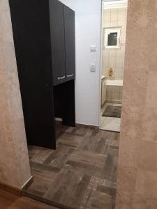 uma casa de banho com um armário preto e piso em madeira em Sweet Home em Buzau