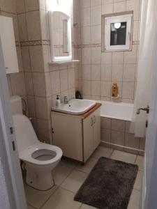 uma casa de banho com um WC, um lavatório e uma banheira em Sweet Home em Buzau