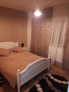 um quarto com uma cama branca e uma janela em Sweet Home em Buzau