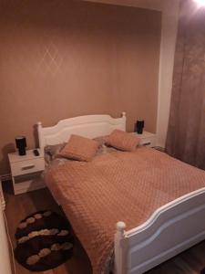 um quarto com uma cama branca e 2 almofadas em Sweet Home em Buzau