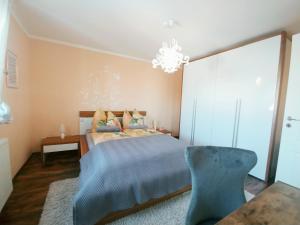 - une chambre avec un lit et un lustre dans l'établissement Wohlfühlzeit im Zittauer Gebirge, à Zittau