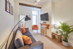 a living room with a blue couch and a chair at Host & Stay - Fountains Cottage in Guisborough