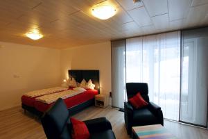 um quarto com uma cama e cadeiras num quarto em Schröder's Hotelpension em Willingen