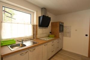 a kitchen with a sink and a window at Schröder's Hotelpension in Willingen