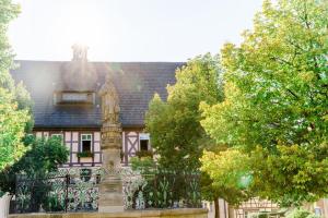 a statue of a woman in front of a building at Hotel Goldner Stern in Königsberg in Bayern