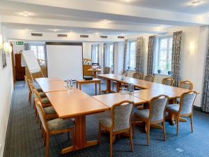 a conference room with tables and chairs and a whiteboard at Hotel Goldner Stern in Königsberg in Bayern