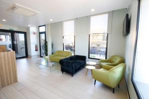 ein Wohnzimmer mit Sofas und Stühlen in einem Gebäude in der Unterkunft Hotel Leo in Monesterio