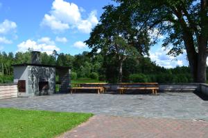 a picnic area with benches and a fireplace in a park at Lodja Jahimaja in Pärnumaa