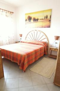 a bedroom with a bed with a plaid blanket at Tanca della Torre Trilocale vista mare in Isola Rossa +33 photos