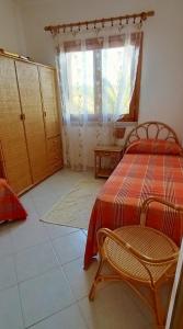 um quarto com 2 camas, uma janela e uma cadeira em Tanca della Torre Trilocale vista mare em Isola Rossa
