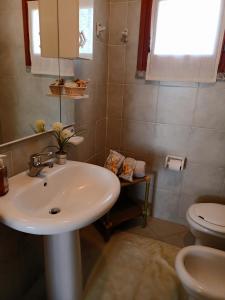 łazienka z umywalką i toaletą w obiekcie Tanca della Torre Trilocale vista mare w mieście Isola Rossa