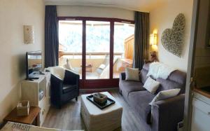 a living room with a couch and a television at Beau deux pièces Isola 2000 in Isola 2000