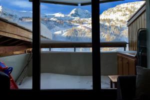 a view of a snowy mountain from a window at Beau deux pièces Isola 2000 in Isola 2000