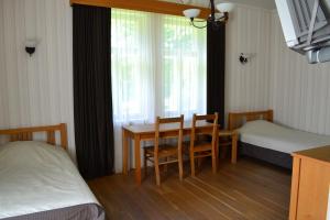 a bedroom with a table and a bed and a window at RMK Lodja Jahimaja in Parnumaa