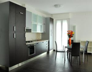 a kitchen with black cabinets and a table with chairs at Casa Vacanze Aurora Centro in Rimini