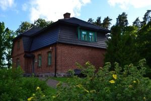 a red brick house with a black roof at Lodja Jahimaja in Pärnumaa