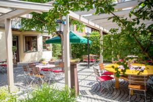 a patio with tables and chairs and an umbrella at Herrenschenke-Café Eiring in Königsberg in Bayern