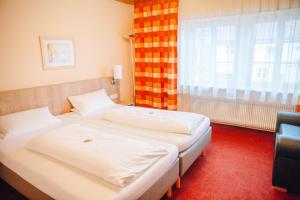 two beds in a room with a window at Herrenschenke-Café Eiring in Königsberg in Bayern