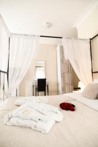 a bed with white towels and roses on it at Garni Hotel Dash in Novi Sad