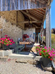 un patio con una mesa y flores en macetas en La Bouchère 33, en Meuzac