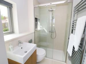 a white bathroom with a sink and a shower at Finest Retreats - Oak House in Tealby