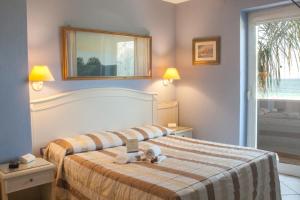 ein Schlafzimmer mit einem Bett mit einem ausgestopften Tier darauf in der Unterkunft Conchiglia Azzurra Resort & Beach in Porto Cesareo