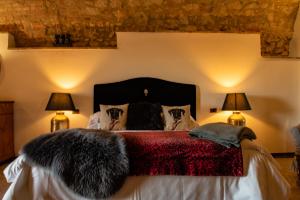 a bedroom with a bed with a black blanket and two lamps at Agriturismo La Chiusa Tuscany in Montefollonico
