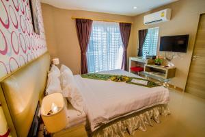 a hotel room with a bed and a television at Retro39 in Bangkok