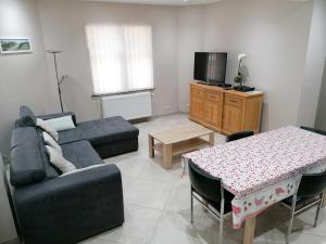 a living room with a couch and a table at Maison au calme à 300m de la plage in De Panne