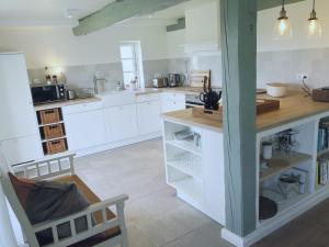 a kitchen with white cabinets and a wooden counter at Tammwarftshof in Pellworm