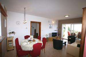 a dining room with a table and red chairs at Apartment Andrina in Vantačići